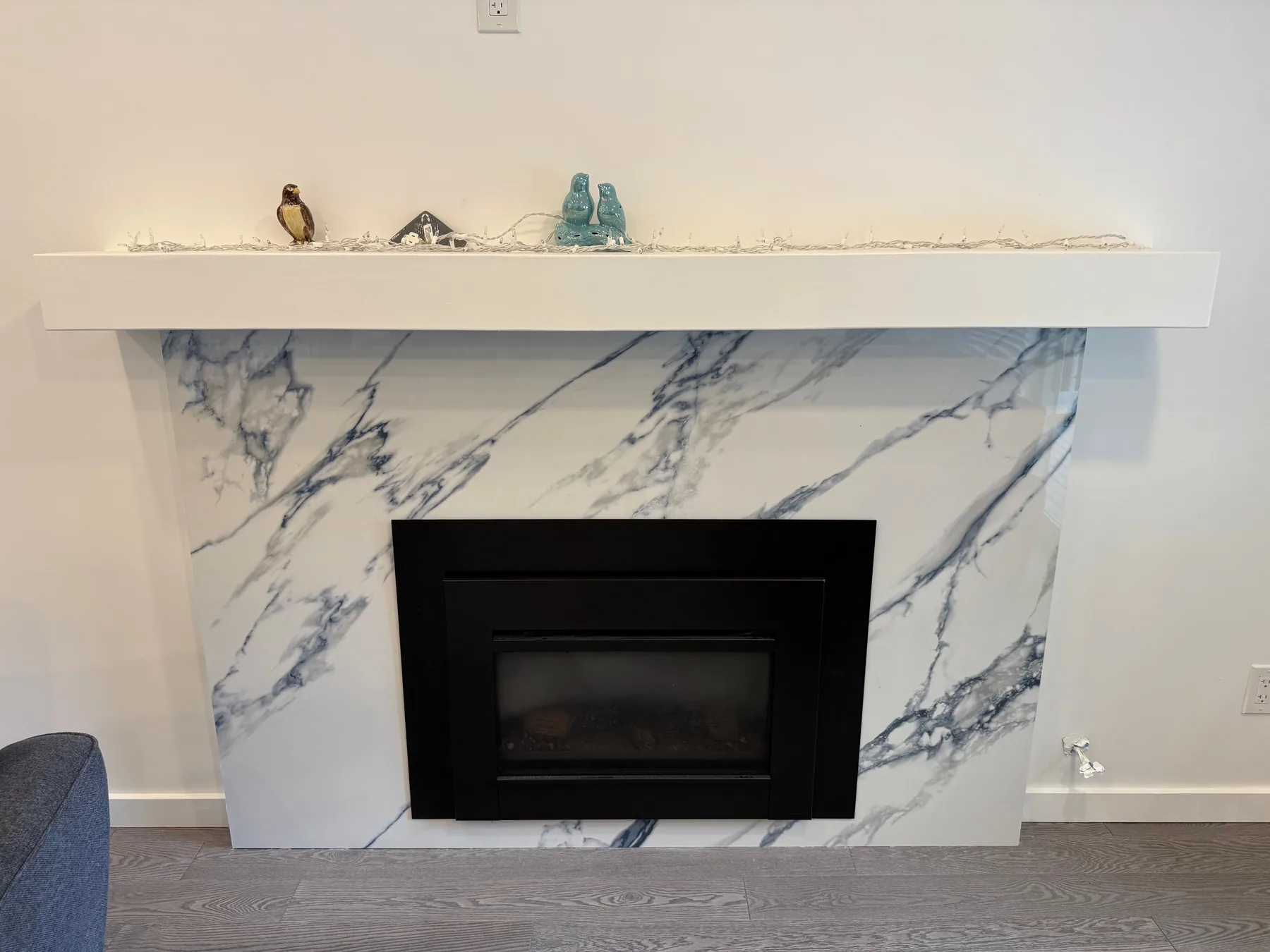 Finished fireplace surround with large-format white and blue-veined panels